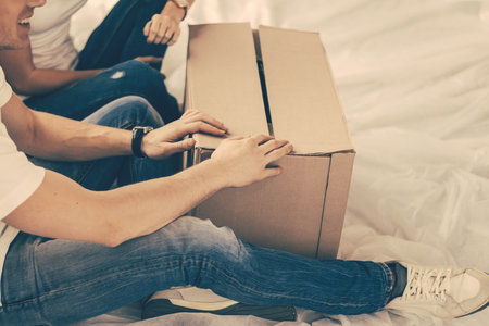 close up. couple opening a large cardboard box.の写真素材