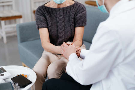 doctor is advising and soothing the woman during a home visit.の写真素材