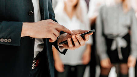 business man choosing contact on his smartphoneの写真素材