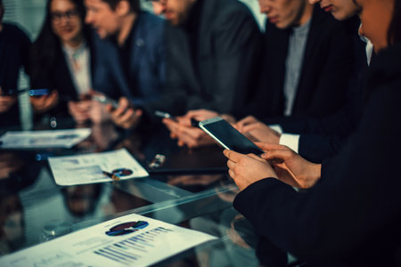 employees using their smartphones to work with financial data.の写真素材