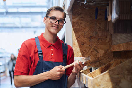 supervisor with a clipboard standing near boxes of nails.