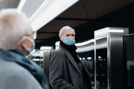 people in protective masks standing on the subway platform.の写真素材