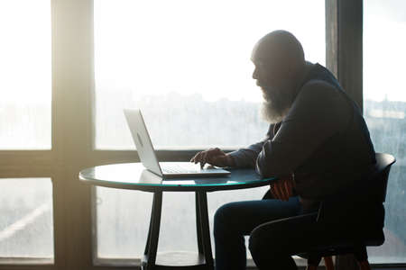 business man using laptop sitting near panoramic window .
