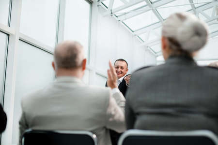 rear view. business people ask questions during a business seminar