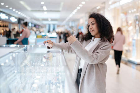 young woman choosing a piece of jewelry in a jewelry store.の写真素材
