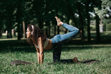 young woman performing a fitness exercise exercise in the park oの写真素材
