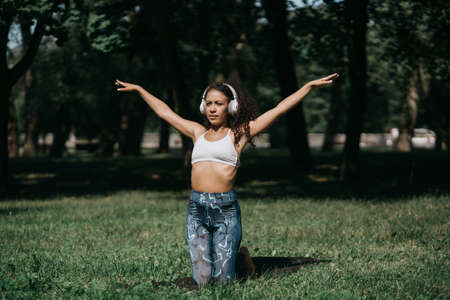 sporty young woman in headphones relaxing in a summer park .の写真素材