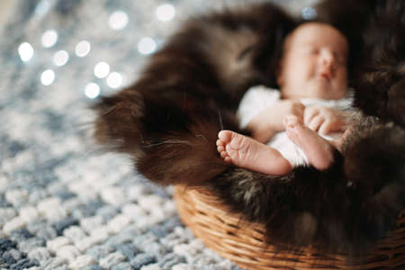 image of a newborn baby sleeping in a baby basket .の写真素材