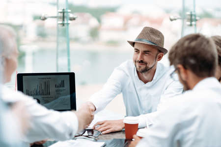 business man in a hat shaking hands with his business partner.の写真素材