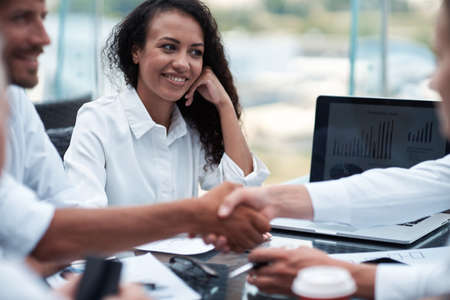happy businesswoman looking at the handshake of business partnerの写真素材
