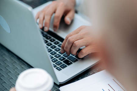 businessman works on a laptop with financial data.