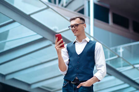 smiling business man reading a message on his smartphone.の写真素材