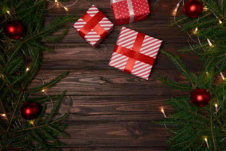 gift boxes and fir branches on a wooden background.の写真素材