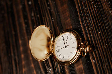 clocks and branches of a Christmas tree on a wooden background .の写真素材