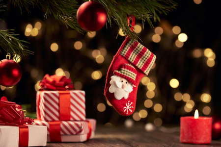 Christmas sock and gift boxes on a festive background.