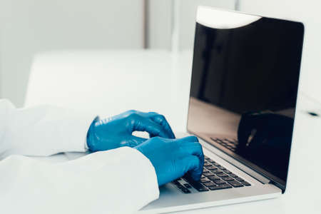 close up. doctor in protective gloves typing on a laptop .の写真素材