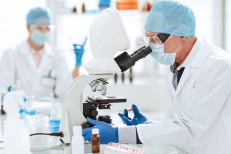 scientist opening an ampoule with a new vaccine .