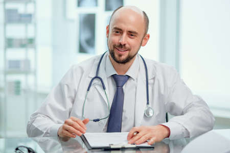 competent doctor conducts an appointment at his medical office .の写真素材