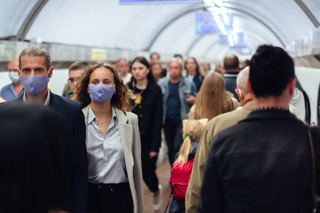 couple in protective masks among the passengers in the subway crossing.の写真素材