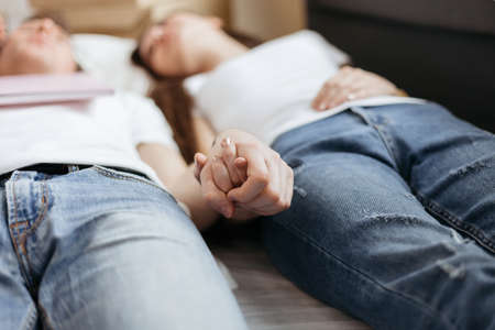 image of a young couple lying on the floor in the living room.の写真素材