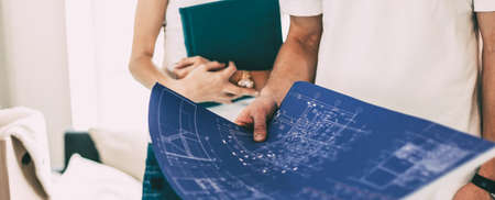 male designer with a drawing standing in a new apartment.の写真素材