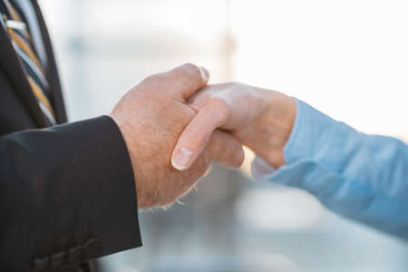 close up. businessman politely shaking hands with a business woman.の写真素材