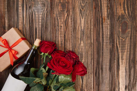 bouquet of flowers, wine and gifts on a wooden background.の写真素材
