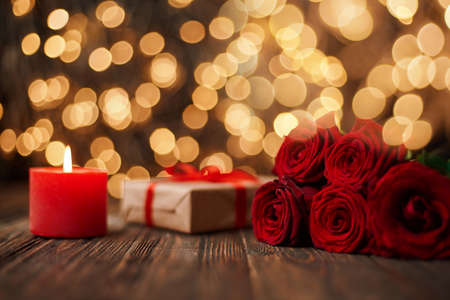 boxes with gifts and a bouquet of flowers on the background of festive lights .の写真素材