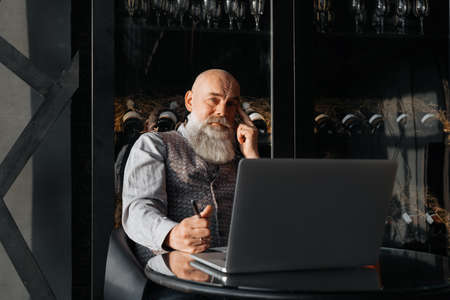 business owner of a liquor store sitting in front of an open laptop .の写真素材