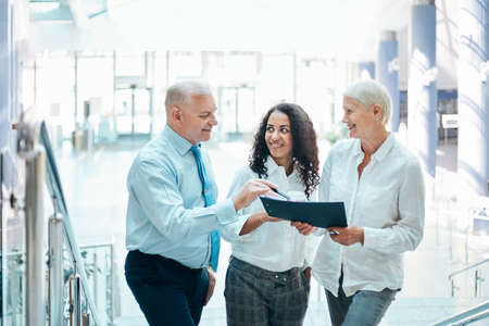 business colleagues discuss a business document standing in the hall of the business center.の写真素材