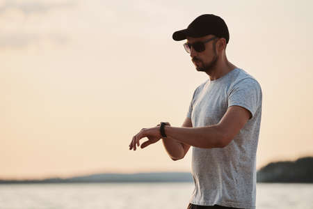 sporty man looking at his smart fitness watch .