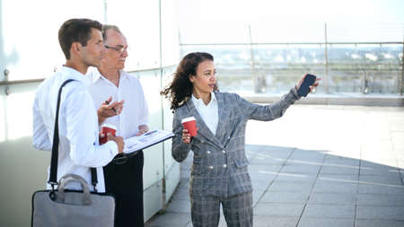 business people discussing something, standing on the terrace of the business center.の写真素材