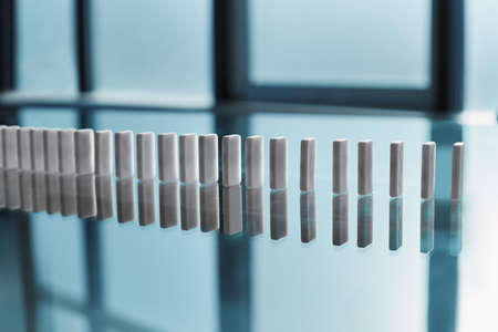 row of domino stones on an office desk.の写真素材