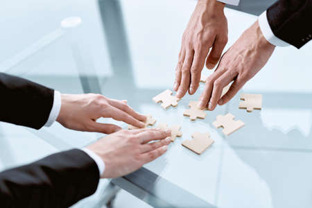 business partners putting together the pieces of the puzzle .の写真素材