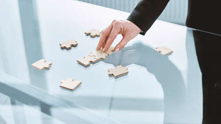 businesswoman starting to put together a puzzle . close-up.