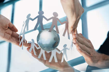 close-up. team of paper men in the hands of business people.