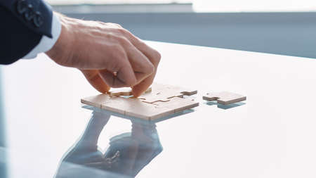 businesswoman starting to put together a puzzle . close-up.