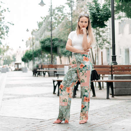 fashionable young woman standing near a street cafe.の写真素材