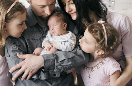 happy father with two daughters and a newborn son.の写真素材