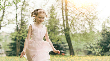 girl runs through dandelions in the parkの写真素材