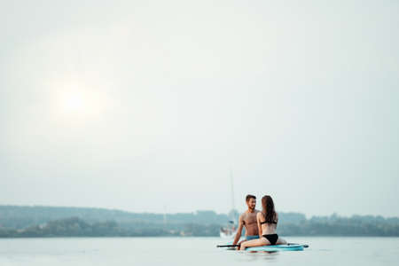 young couple in love is kissing sitting on the SAP board .の写真素材
