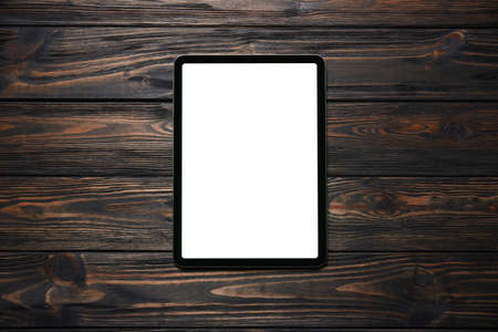 tablet computer with a green screen on a wooden background.