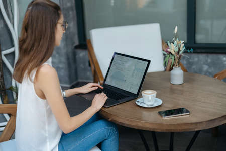 young woman with a cup of coffee sitting in a cozy cafe.