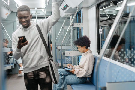 smiling guy with a smartphone standing in a subway car .の写真素材