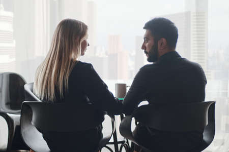 businessman and businesswoman talking sitting at a coffee table.の写真素材