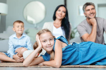 little girl lying on the floor in front of her family.の写真素材
