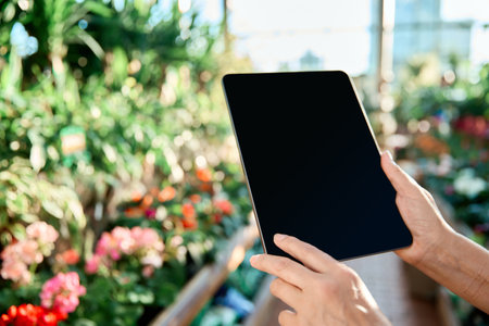 female customer with a digital tablet in a flower shop.