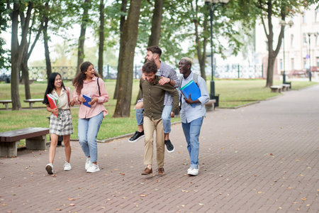 happy friends students walking along the path of the park.の写真素材