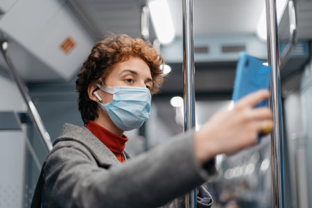 young woman taking a selfie standing in a subway car.の写真素材
