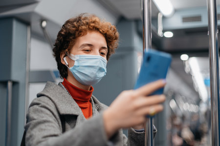 young woman talking on her smartphone in a subway car.の写真素材